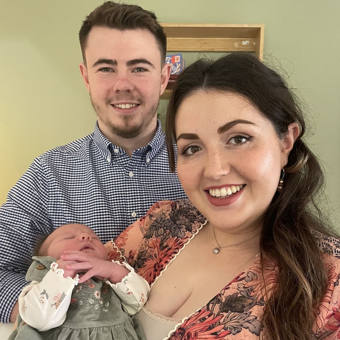 Conor and Erin cheek to cheek with newborn Florence asleep in Erin’s arms