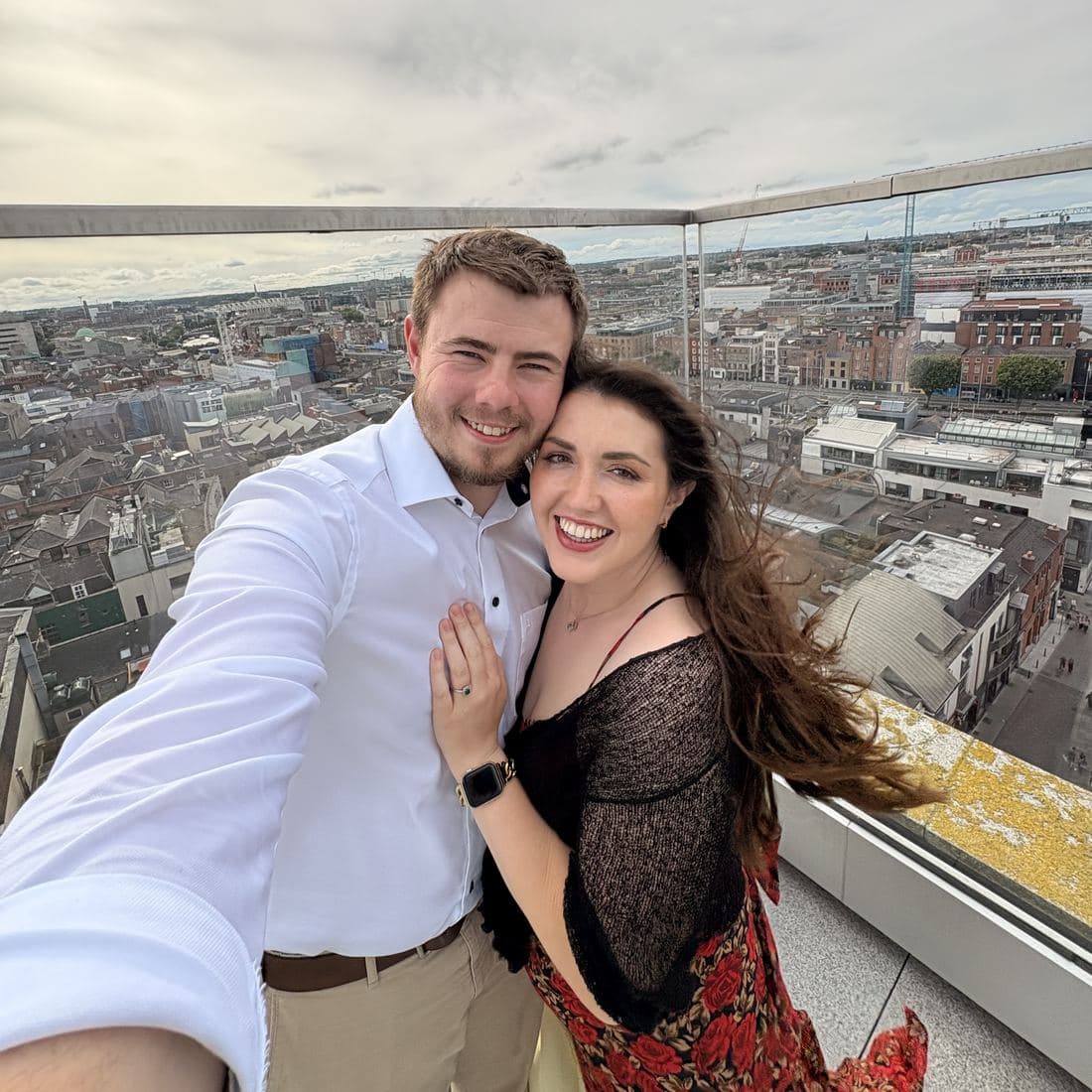 Conor and Erin taking a selfie on a rooftop terrace above the Dublin skyline on a bright summer evening